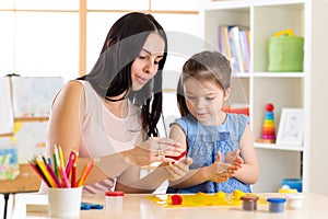 Kid creativity. Child girl with her mother sculpting from play clay