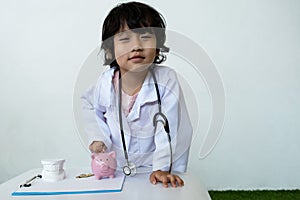 Kid doctor and Medical equipment with pink piggy bank, Saving money for future plan and Health insurance concept