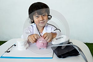 Kid doctor and Medical equipment with pink piggy bank, Saving money for future plan and Health insurance concept