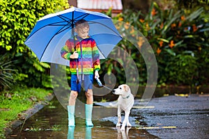 Kids in puddle in autumn rain. Waterproof wear