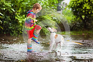 Kids in puddle in autumn rain. Waterproof wear