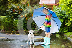 Kids in puddle in autumn rain. Waterproof wear