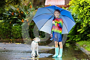 Kids in puddle in autumn rain. Waterproof wear