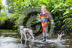 Kids in puddle in autumn rain. Waterproof wear