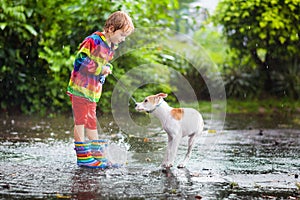 Kids in puddle in autumn rain. Waterproof wear