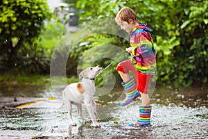 Kids in puddle in autumn rain. Waterproof wear