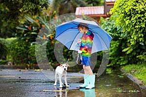 Kids in puddle in autumn rain. Waterproof wear