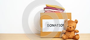 Kid Donation, Charity, Volunteer, Giving and Delivery Concept. Bear doll and Clothes with Donation box at home for support and