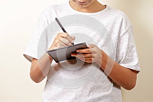 Kid drawing with graphic tablet and stylus pen