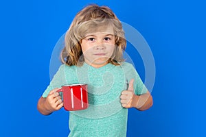 Kid drinking a fresh glass of water, isolated on studio background. Thirsty kid holding glass drinks water. Dehydration