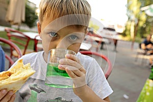 Kid drinking green lemonade