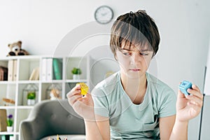 Kid with dyslexia holding wooden building blocks