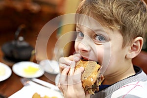 Kid eating burger in restaurant