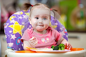 Kid eating food on kitchen