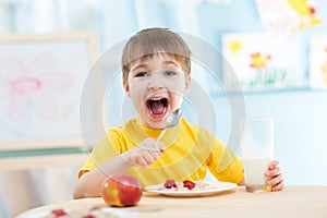 Kid eating healthy food at home