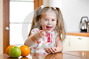 Kid eating healthy food in kitchen