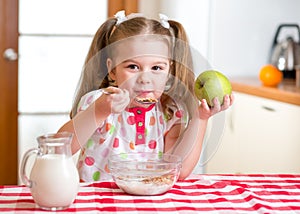 Kid eating healthy food in kitchen