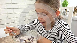 Kid eating milk and cereals at breakfast, child in kitchen, teenager girl tasting healthy food at meal, nutrition