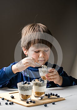 Kid eating parfait. Child eats organic food. Healthy vegetables with vitamins. Proper kids nutrition concept