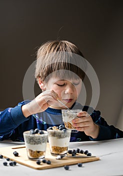 Kid eating parfait. Child eats organic food. Healthy vegetables with vitamins. Proper kids nutrition concept