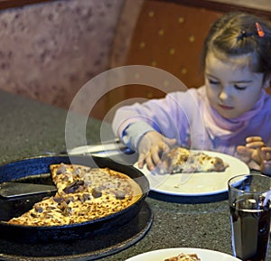 Kid eating pizza in restaurant background