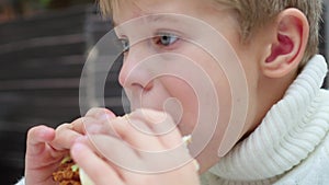 The kid eats a sandwich at a fast food restaurant closeup