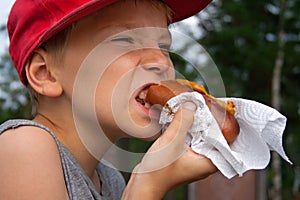 Kid eats sausage