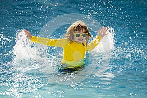 Kid enjoying summer holiday, swiming in pool. Kid having fun on summer holidays at pool. Happy kids playing on pool