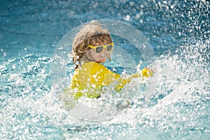 Kid enjoying summer holiday, swiming in pool. Kid having fun on summer holidays at pool. Happy kids playing on pool