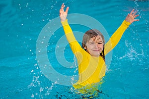 Kid enjoying summer holiday, swiming in pool. Kid having fun on summer holidays at pool. Happy kids playing on pool