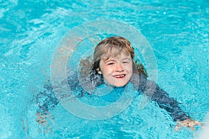 Kid enjoying summer vacation, swim in swiming pool. Kid swiming and having fun on summer vacation. Happy kids swiming on