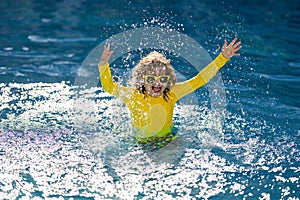 Kid enjoying summer vacation, swim in swiming pool. Kid swiming and having fun on summer vacation. Happy kids swiming on