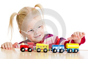 Kid in eyeglases playing toy train isolated photo