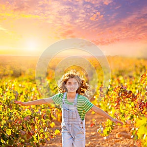 Kid farmer girl running in vineyard field in autumn