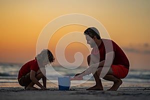 Kid and father building sandcastle. Father and son playing on the beach. Father and child son playing in the sand on