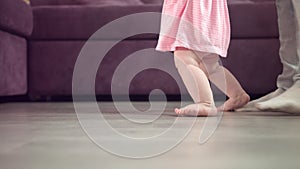Kid feet walking on floor. Baby feet steping at home. Child first step