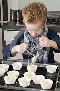 Kid Filling Cakecups With Dough