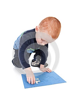 Kid finishing puzzle with last and final piece