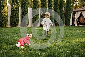 Kid with funny doggy walking in the garden