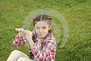 Kid gadabout. Girl little kid spend leisure outdoors in park. Girl sit on grass in park. Child enjoy spring sunny