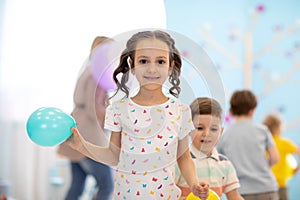 Kid girl with balloon on children party background