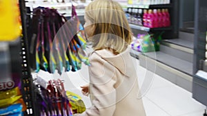 a kid girl chooses sweets in the store. sale of goods for children.