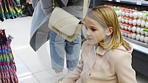 a kid girl chooses sweets in the store. sale of goods for children.