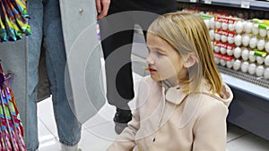 a kid girl chooses sweets in the store. sale of goods for children.