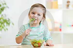 Kid girl eating healthy vegetables