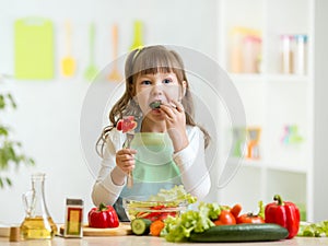 Kid girl eating healthy vegetables