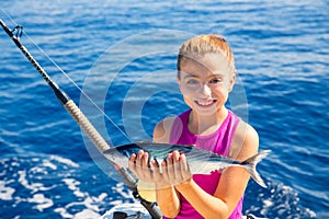 Kid girl fishing tuna bonito sarda fish happy with catch
