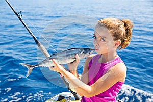 Kid girl fishing tuna bonito sarda kissing fish for release