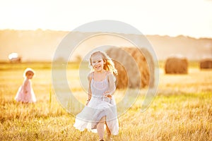 Kid girl grey dress run on sloping wheat field