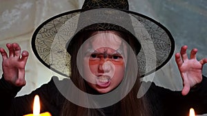 Kid girl in Halloween costume looking at camera with frightening expression